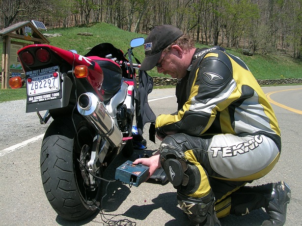 [Using the 12-volt compressor to refill the tire with air.]