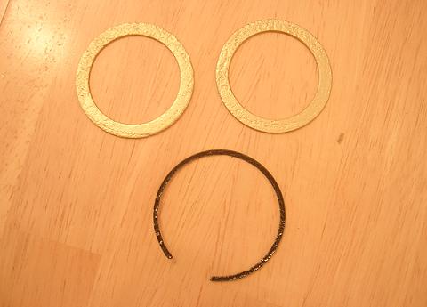 [The two fork washers and one of the retaining rings after being cleaned of all rust and repainted.]