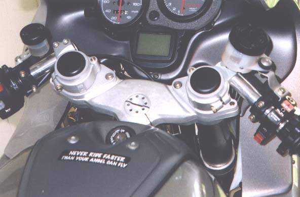 [Picture of the Helibar adapters with Ducati SBK clip-ons to lower the bars.]