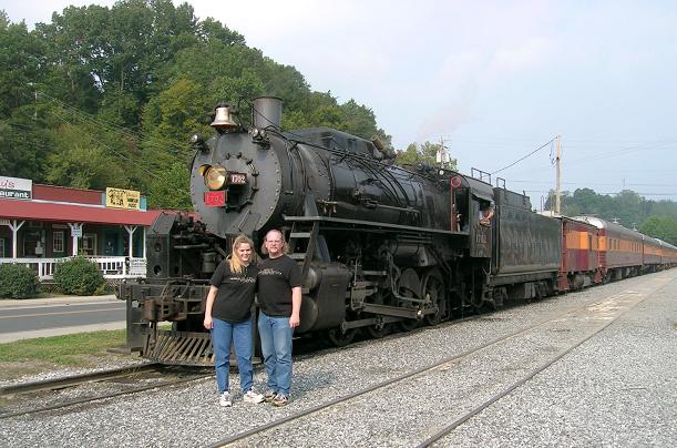 [Vicki and I are posing in front of the train in Bryson City.]